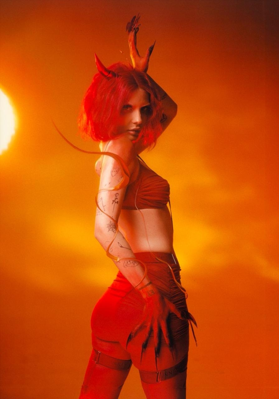 Lucille Croft with horns against an orange sun